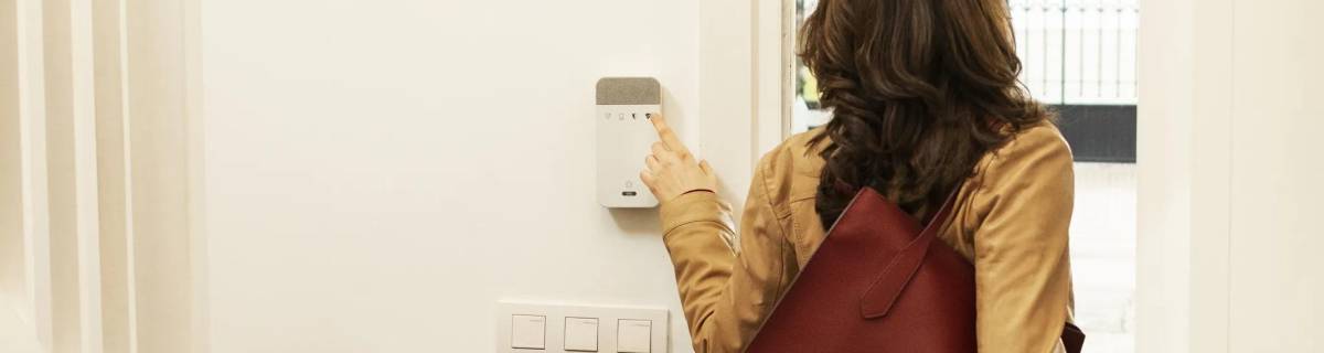 Mujer saliendo de casa activando alarma
